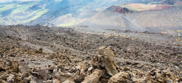 travel to Italy - cloud on frozen lava field on Mount Etna in Sicily in summer day