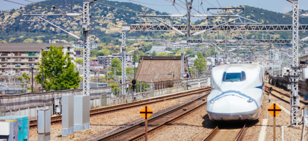 A Shinkansen high-speed bullet train pulling into a train station in Japan