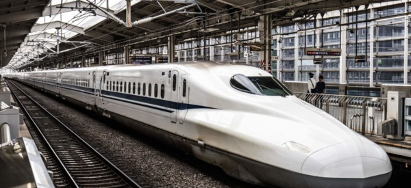 A Shinkansen high-speed bullet train pulling into a train station in Japan